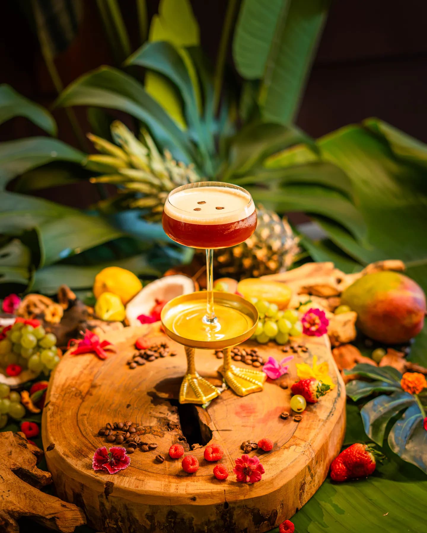 Espresso martini con tres granos de café en una copa con pie dorado con forma de patas de pato
